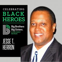 Jesse T. Heron on the right, smiling and wearing a black suit jacket and a blue. On the left, a banner that says, "Celebrating Black Heroes" on top of the BBBS Logo, with "Jesse T. Herron" underneath