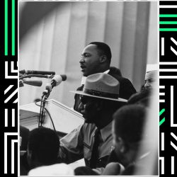 Martin Luther King Jr., in black and white, delivering a speech from the podium.