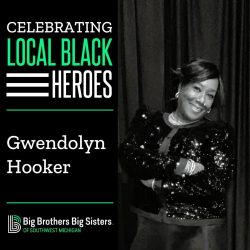 On the left: "Celebrating Local Black Heroes" on top of the name "Gwendolyn Hooker," on top of the BBBS logo. On the right, Gwendolyn stands, arms crossed and wearing a black dress, smiling at the camera.