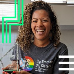 Big Brothers Big Sisters Strategic Engagement Manager Carmen James holds a Biggie Award and smiles at the camera.