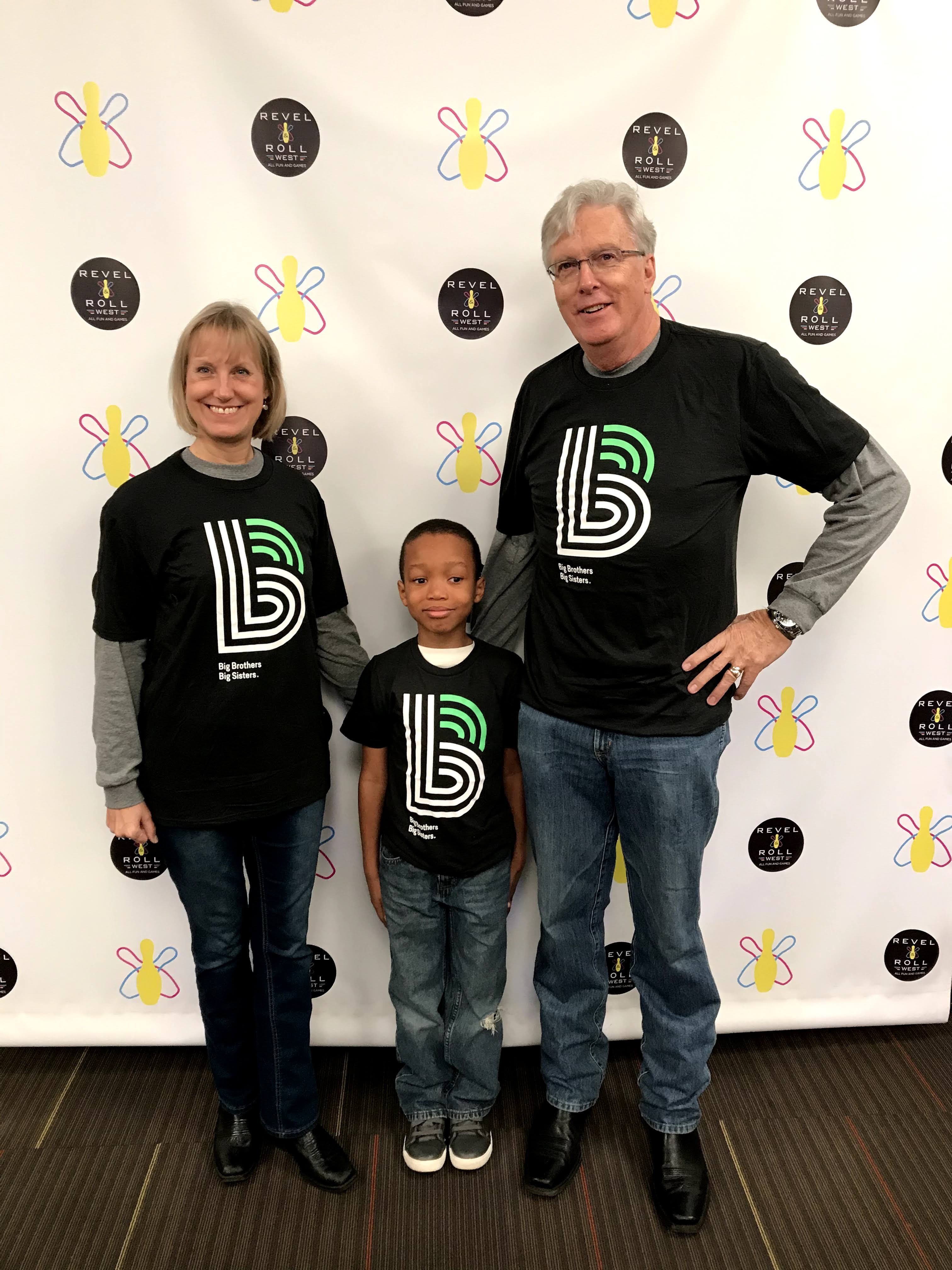 From left: Mary, Jeremiah, and Paul stand smiling at the camera wearing BBBS tshirts.