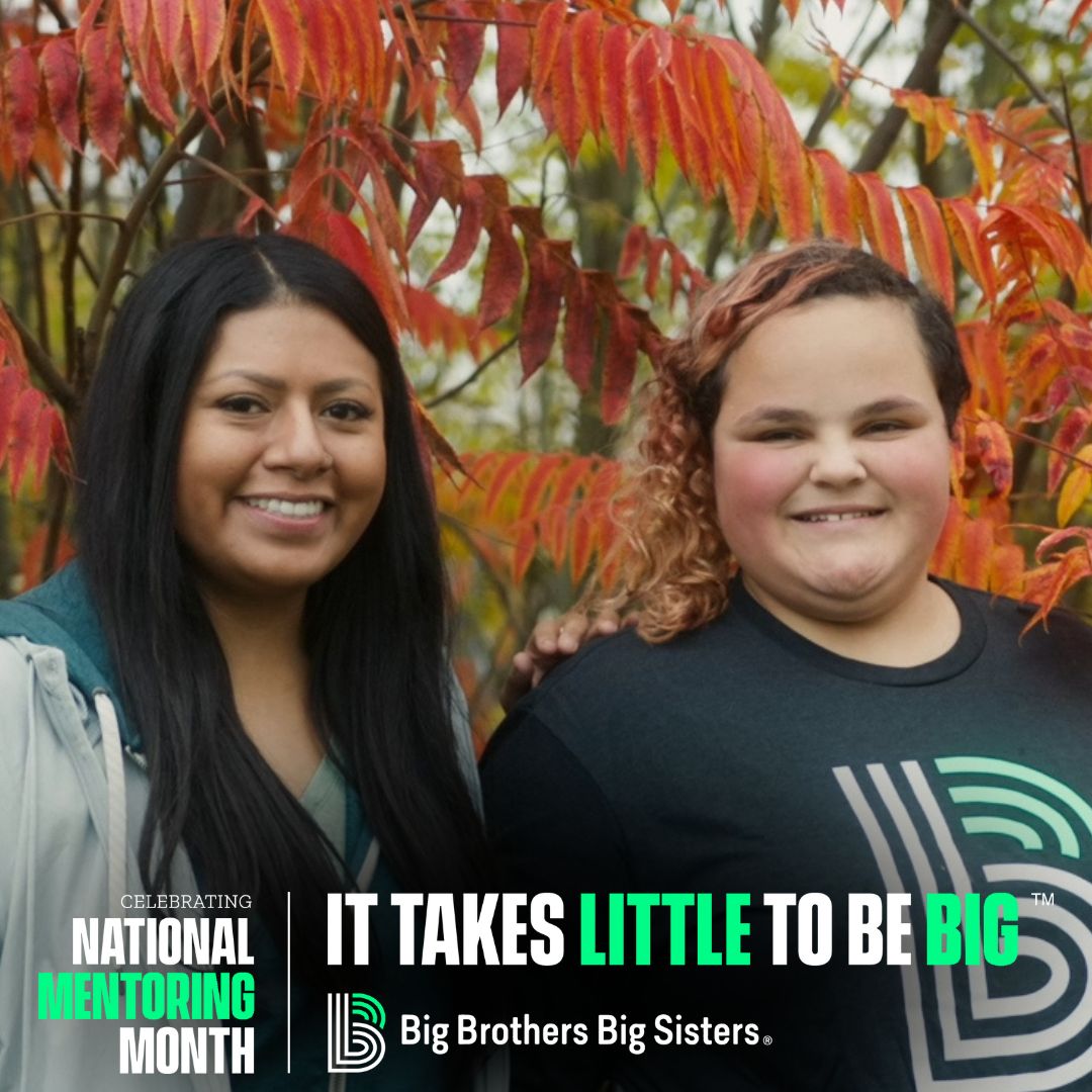 Celeste and Asira stand in front of an orange-leaf tree, smiling at the camera. Across the bottom it says "Celebrating National Mentoring Month | It Takes Little To Be Big" atop the horizontal BBBS logo.