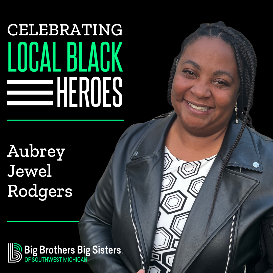On the left: Celebrating Local Black Heroes, Aubrey Jewel Rodgers, on top of the horizontal BBBSMI logo. On the right, a headshot of Aubrey Jewel Rodgers smiling at the camera, wearing a black leather jacket with a black and white patterned top underneath.