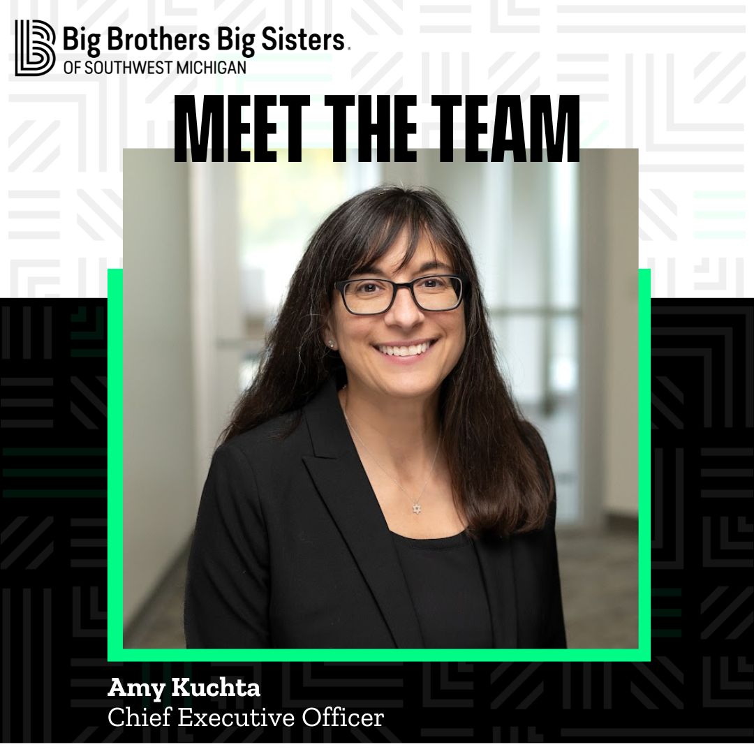Upper left hand corner: The all-black horizontal BBBSMI logo. In the center is a headshot of Amy Kucha, smiling at the camera, wearing a black blazer. Above her are the words "Meet the Team." In the lower left hand corner are the words "Amy Kuchta, Chief Executive Officer"