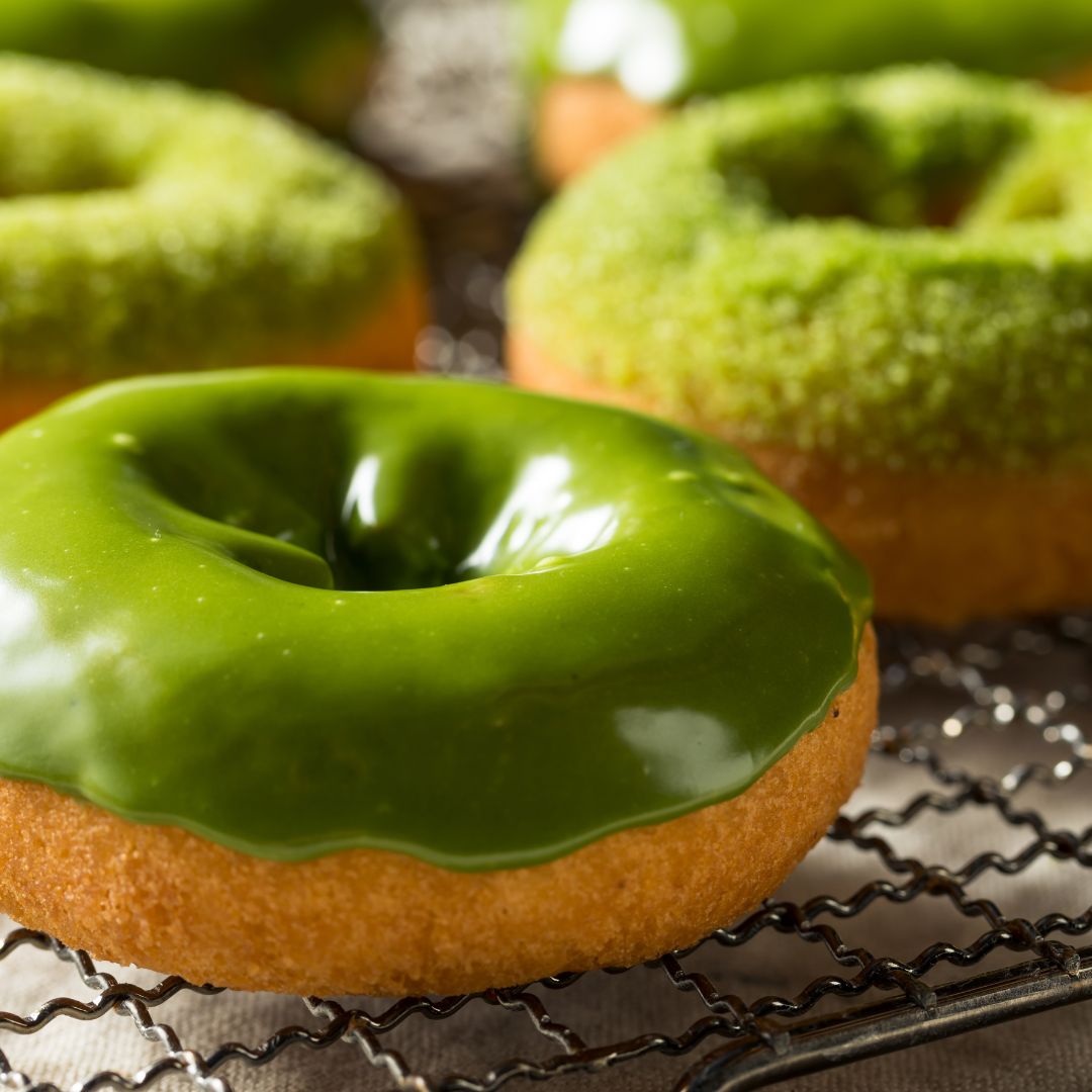 Green donuts on a cookie rack