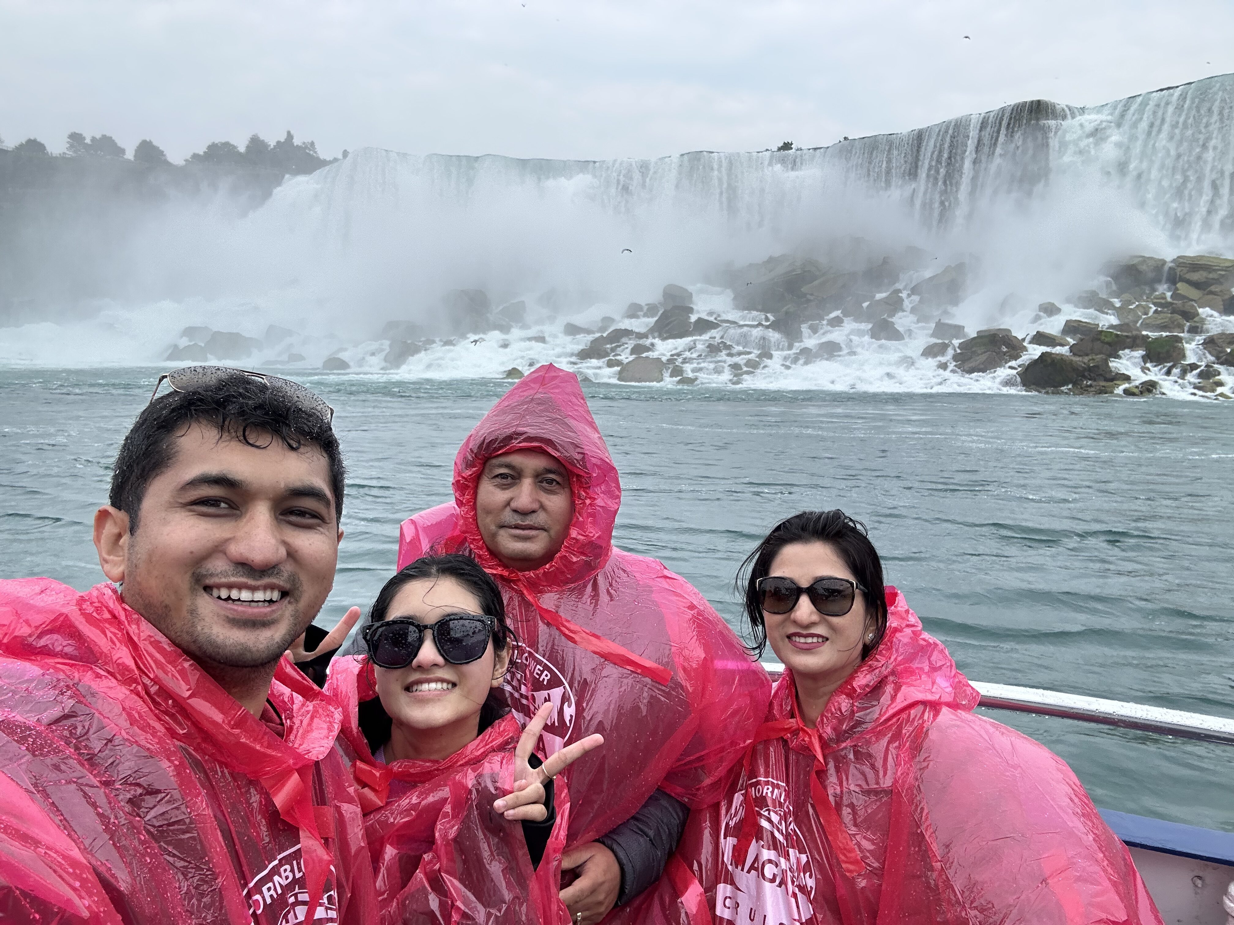 Asmina stands smiling with some family members in front of Niagara Falls.